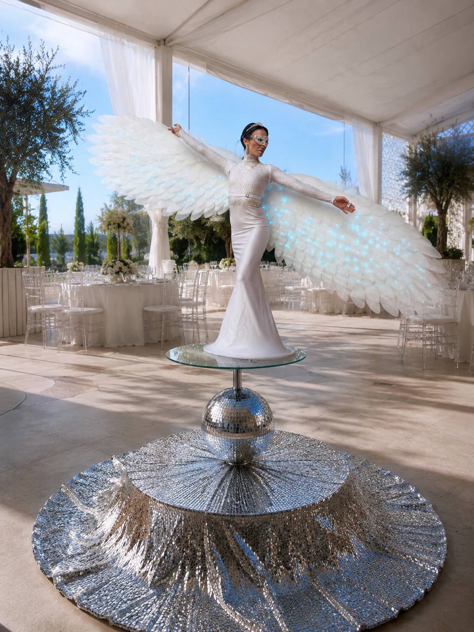 Performer in a white feathered angel-wing costume on the Disco Luxe Platform — Las Vegas event