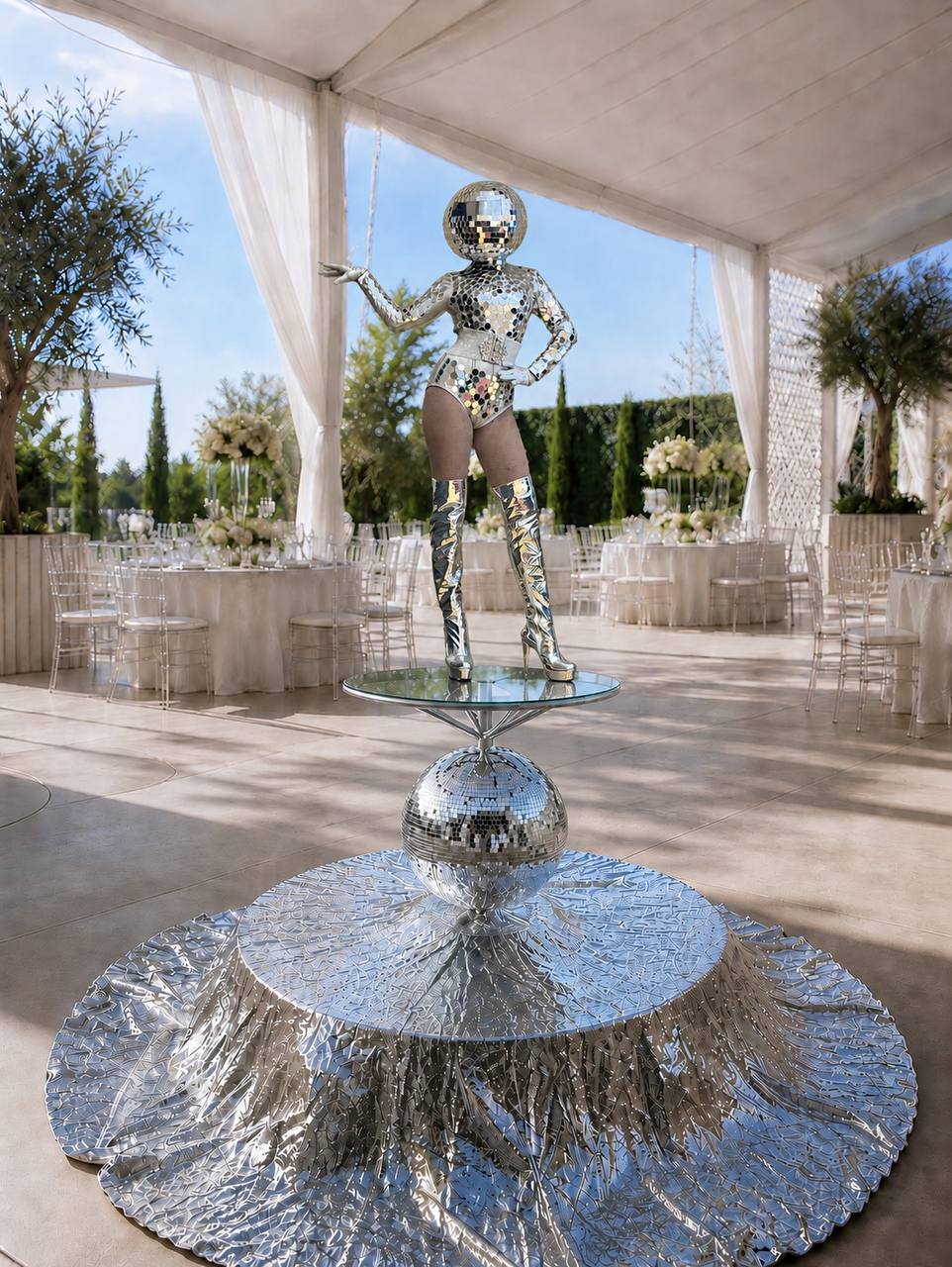 Mirror-ball costumed performer standing on the Disco Luxe Platform in a white event tent — Las Vegas