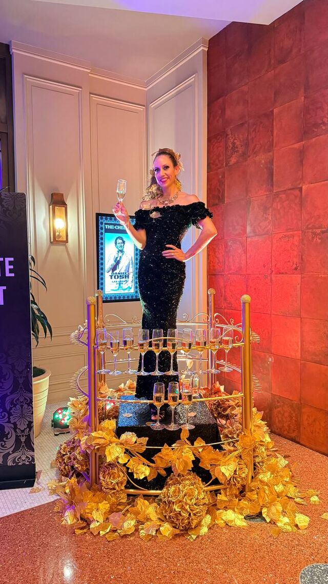 Model raising a champagne glass inside the station