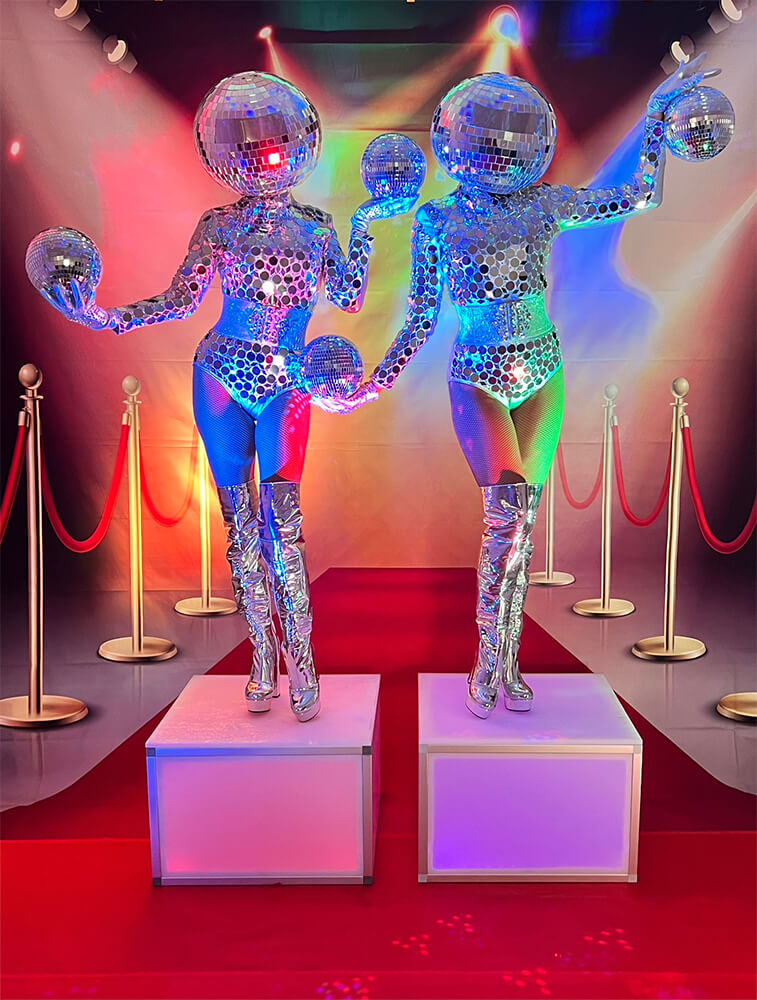 Disco-ball costumed models on go-go boxes, red carpet