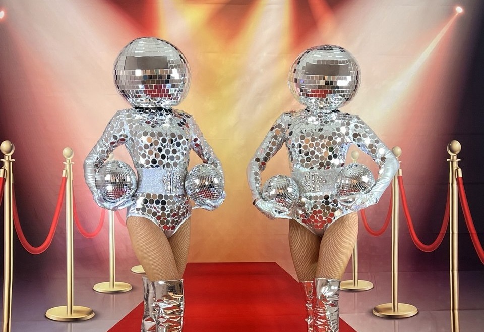 Models/Characters performers with disco-ball heads on red carpet